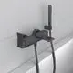 Wandmontierte Armatur in Magnetgrau von Ideal Standard, mit Brause und Schlauchanschluss, platziert über einer Badewanne an einer hellen Wand.